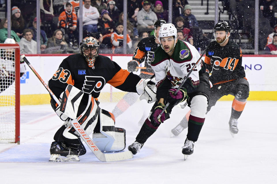 Philadelphia Flyers goaltender Samuel Ersson, left, looks for the puck past Arizona Coyotes' Jack McBain (22) during the first period of an NHL hockey game, Monday, Feb. 12, 2024, in Philadelphia. (AP Photo/Derik Hamilton)