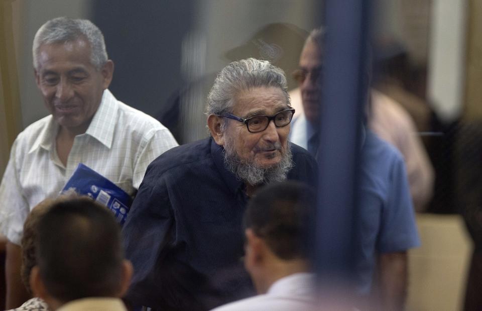 FILE - In this Feb. 28, 2017 file photo, Abimael Guzman, founder and leader of the Shining Path guerrilla movement, center, enters a courtroom at the Naval Base in Callao, Peru. The Peruvian government reported Saturday, Sept. 11, 2021, that Guzman died after an illness. (AP Photo/Martin Mejia, File)