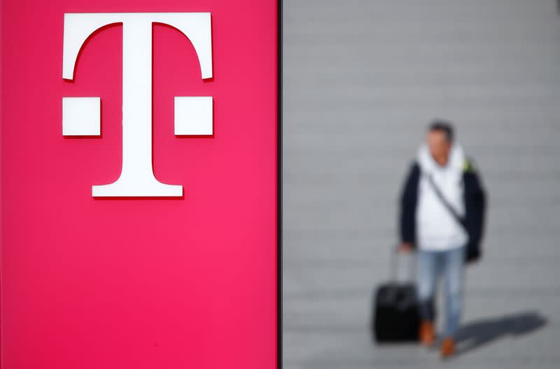 A man walks past the logo of Deutsche Telekom AG at the headquarters of German telecommunications giant in Bonn