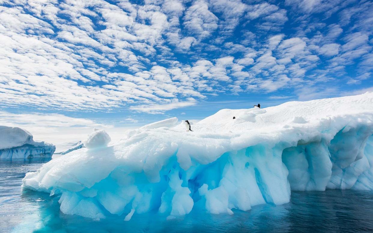 Cloud patterns over an iceberg in Antarctica penguins