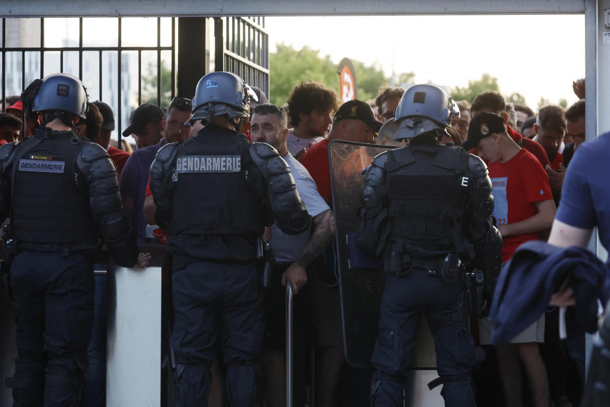 Soccer Football - Champions League Final - Liverpool v Real Madrid - Stade de France, Saint-Denis near Paris, France - May 28, 2022  Fans and police officers at the turnstiles inside the stadium as the match is delayed REUTERS/Gonzalo Fuentes