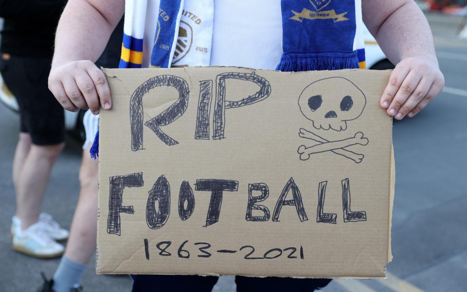 A Leeds United fan holds up a sign reading "RIP Football 1863-2021" in protest to the European Super League outside the stadium prior to the Premier League match between Leeds United and Liverpool at Elland Road on April 19, 2021 in Leeds, England. Sporting stadiums around the UK remain under strict restrictions due to the Coronavirus Pandemic as Government social distancing laws prohibit fans inside venues resulting in games being played behind closed doors - Getty Images