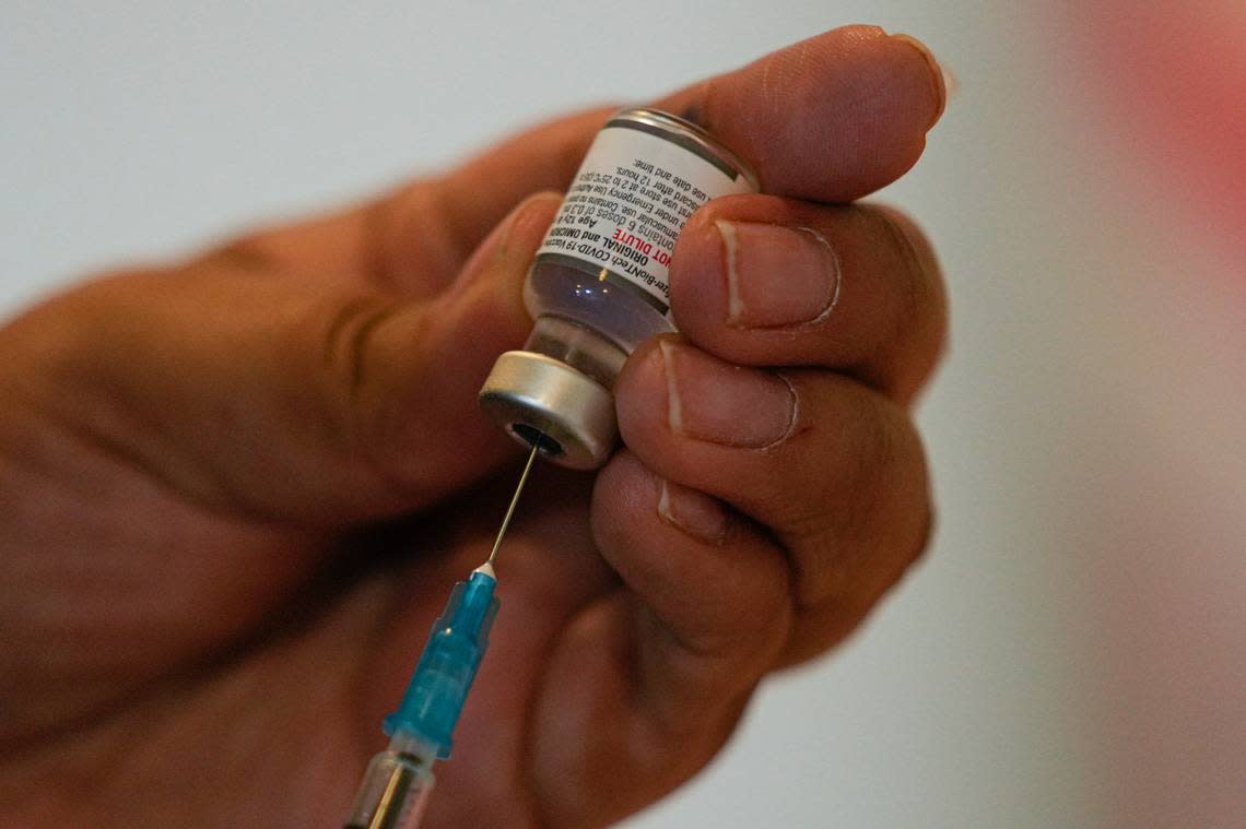 A healthcare worker prepares a dose of the COVID-19 bivalent booster at the start of a vaccination campaign for people 80 years and older. (AP Photo/Esteban Felix)