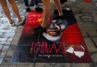 Pedestrians step on a caricature of Hong Kong Chief Executive Carrie Lam, part of a newly created Lennon Wall in Hong Kong, Saturday, Sept. 28, 2019. Hong Kong activists first created their own Lennon Wall during the 2014 protests, covering a wall with a vibrant Post-it notes calling for democratic reform. Five years later, protestors have gathered to create impromptu Lennon Walls across Hong Kong island. (AP Photo/Vincent Yu)