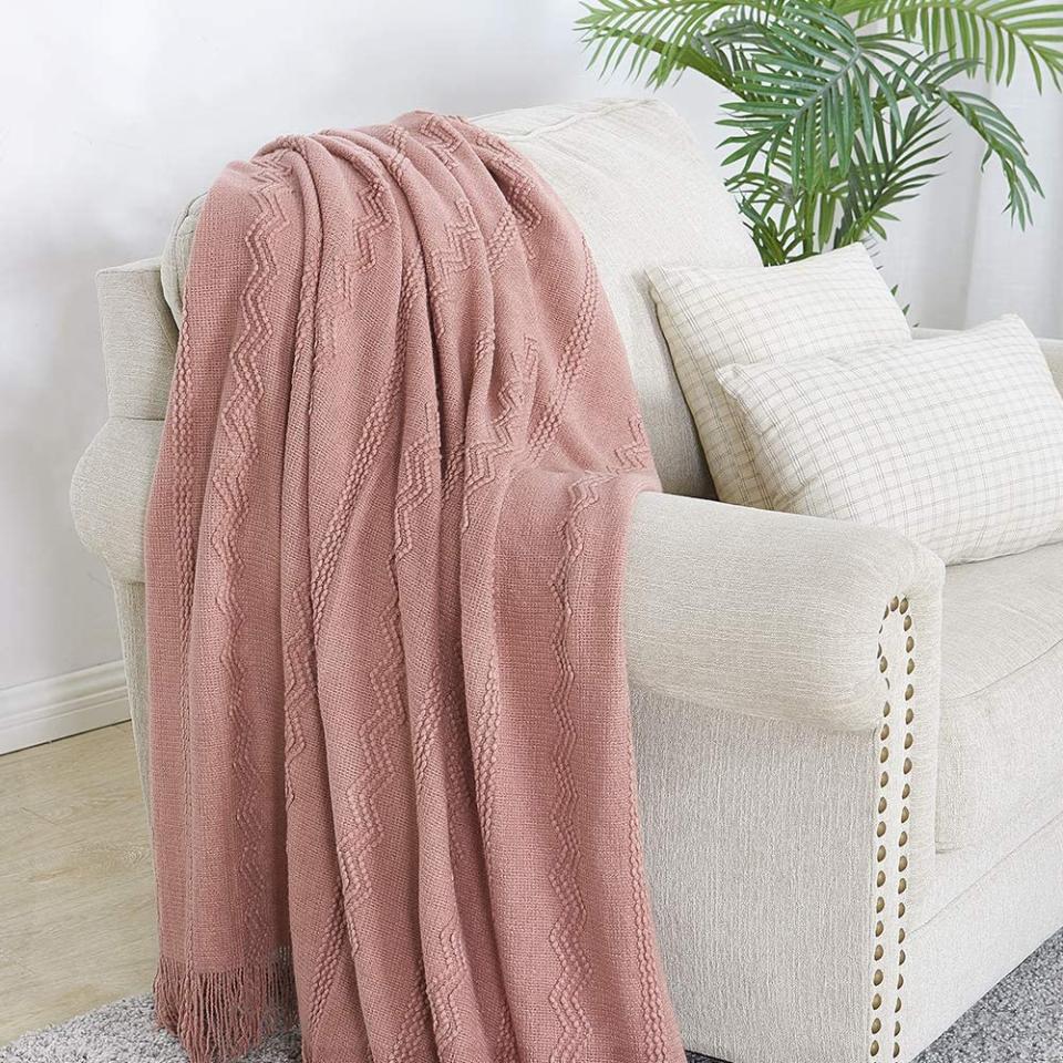 blush blanket thrown over a white armchair