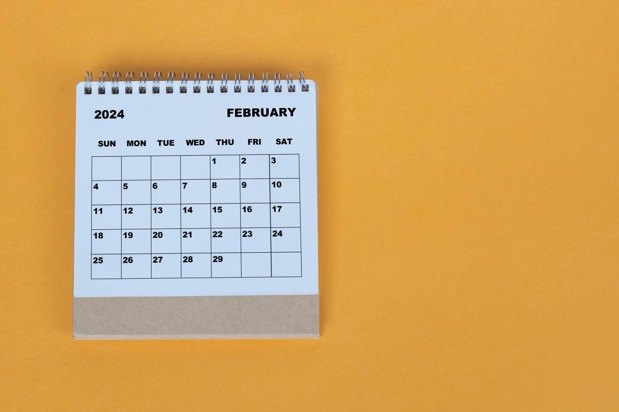 February 2024 desk calendar on yellow background.