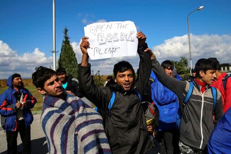 Refugees and migrants stage a protest as they take a break at a petrol station before abandoning their trek to the Hungarian border, in the town of Indjija, Serbia October 5, 2016. REUTERS/Marko Djurica