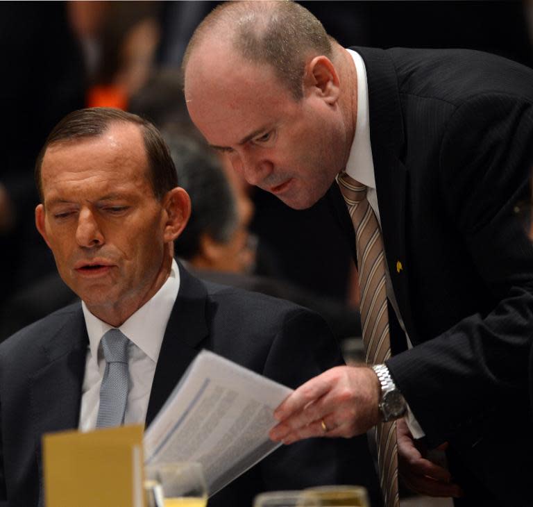 Then Australian Ambassador in Indonesia, Greg Moriarty (R), talks to visiting PM Tony Abbott during a forum in Jakarta, in 2013