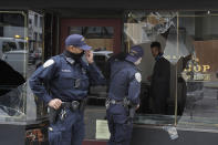 Police officers talk to a man through a broken window of Goorin Bros. Hat Shop in San Francisco, Sunday, May 31, 2020, after protests over the Memorial Day death of George Floyd. Floyd was a black man who was killed in police custody in Minneapolis on May 25. (AP Photo/Jeff Chiu)