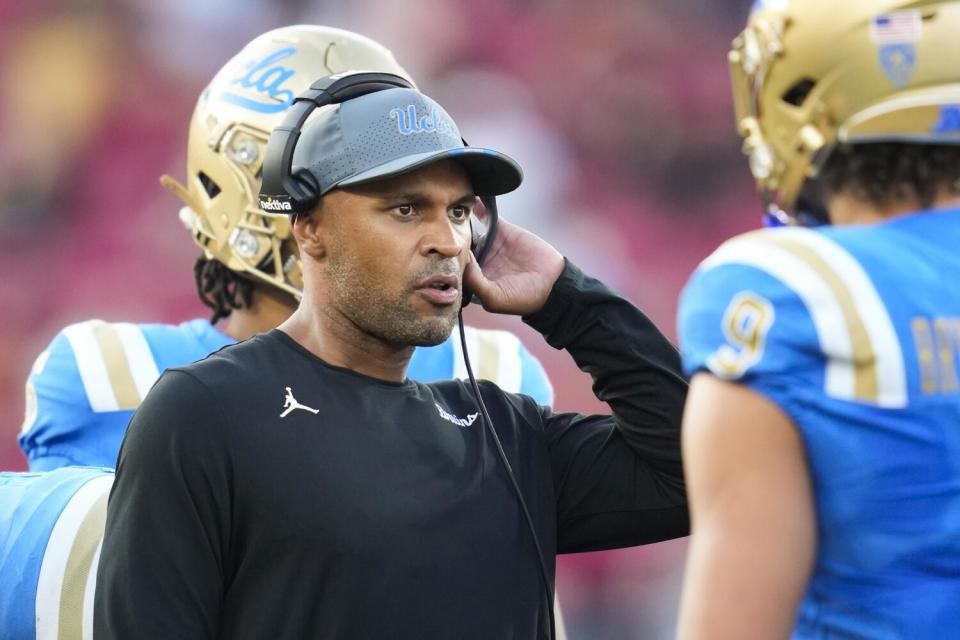 D'Anton Lynn talks with linebacker Choe Bryant-Strother during a timeout.