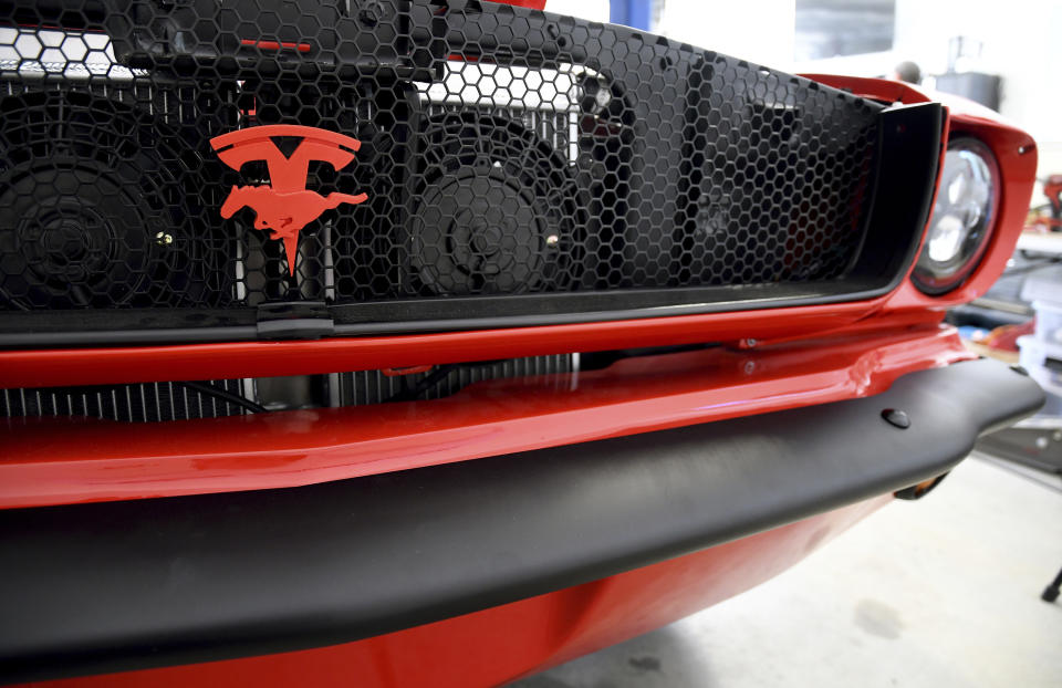 The front grille of an electrified 1965 Ford Mustang is seen at Inspire EV's garage in Arvada, Colo., on Sept. 23, 2022. A small but expanding group of tinkerers, racers, engineers, and entrepreneurs across the country are converting vintage cars and trucks into greener, often much faster, electric vehicles. (AP Photo/Thomas Peipert)