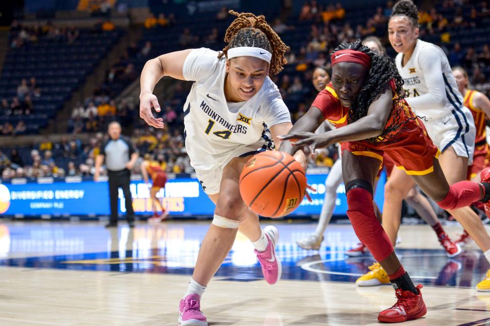 West Virginia forward Kari Niblack (14) and Iowa State forward Nyamer Diew reach for the ball during the first half of an NCAA college basketball game in Morgantown, W.Va., Saturday, March 5, 2022.