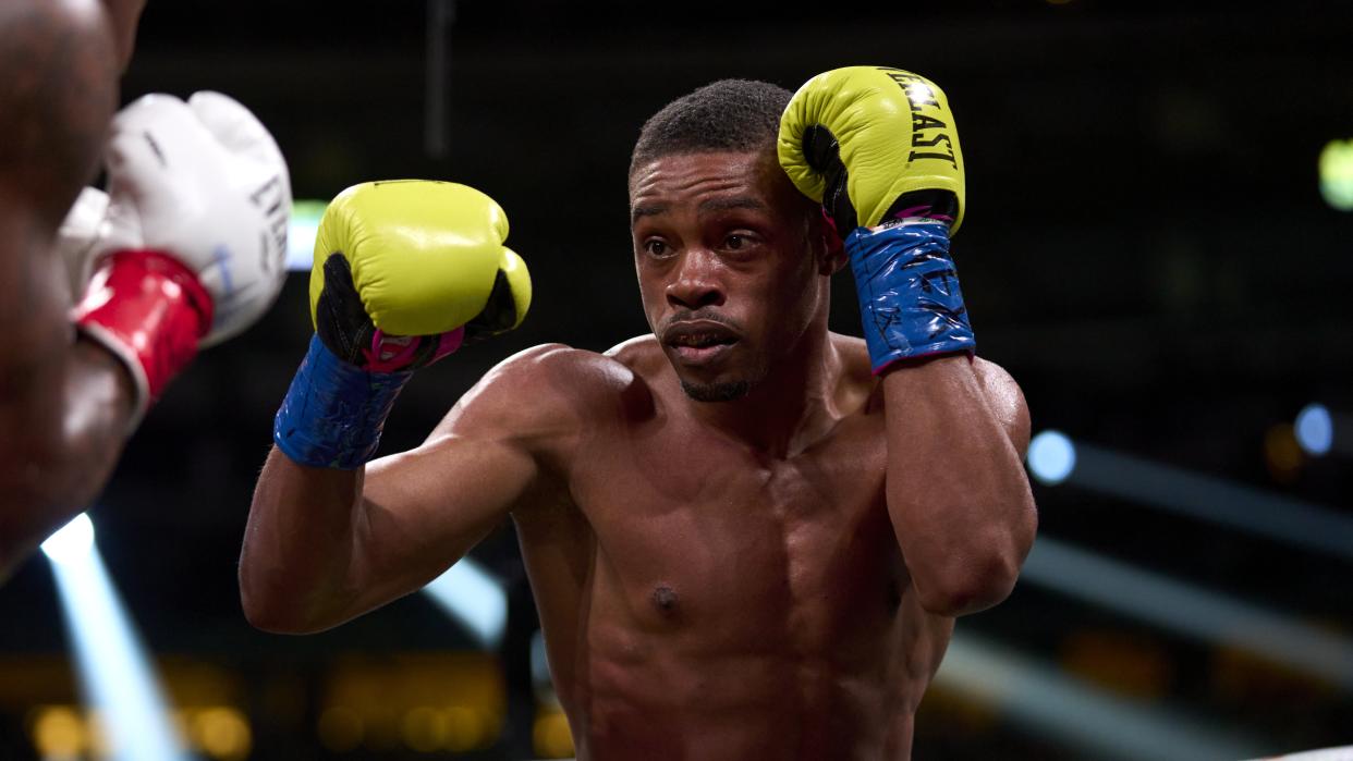  Errol Spence Jr. holds his lime green gloves up during a professional boxing match.  