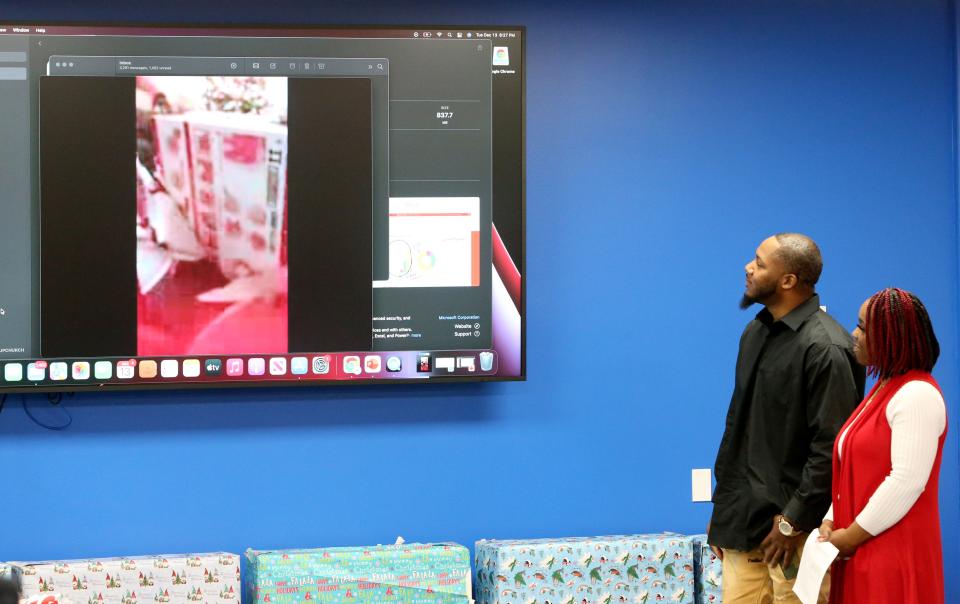 Christopher Stephens and Shanette Smiley watch a video of their daughter open her Christmas present where she received a Barbie Dream House. The video was shown Tuesday, Dec. 13, 2022, at the Forever 7 Barbie Dream House gift distribution at the Excel Center in South Bend for 24 girls in the memory of Chrisyah Stephens.