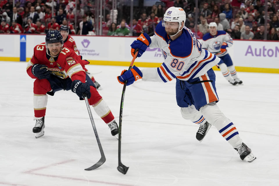 Edmonton Oilers defenseman Markus Niemelainen (80) passes the puck as Florida Panthers center Sam Reinhart (13) defends during the second period of an NHL hockey game, Saturday, Nov. 12, 2022, in Sunrise, Fla. (AP Photo/Lynne Sladky)