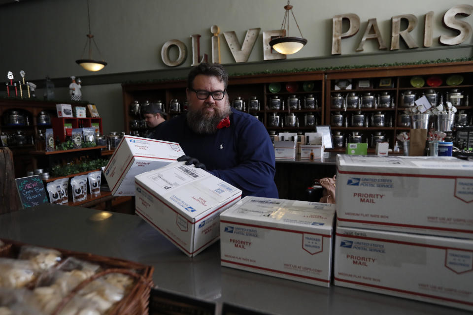 Daryl Felsberg, who along with his wife Heather, own Olive Paris, off the town square prepares orders for shipping at his store in Paris, Texas, Wednesday, April 29, 2020. Barely a week ago, rural Lamar County could make a pretty good argument for Texas' reopening Friday. Only a handful of the 50,000 residents here, right on the border with Oklahoma, had tested positive to that point for the coronavirus. None had died. (AP Photo/Tony Gutierrez)