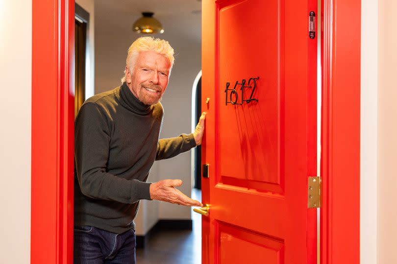 Sir Richard Branson opening the door to a hotel room inside a Virgin Hotels site