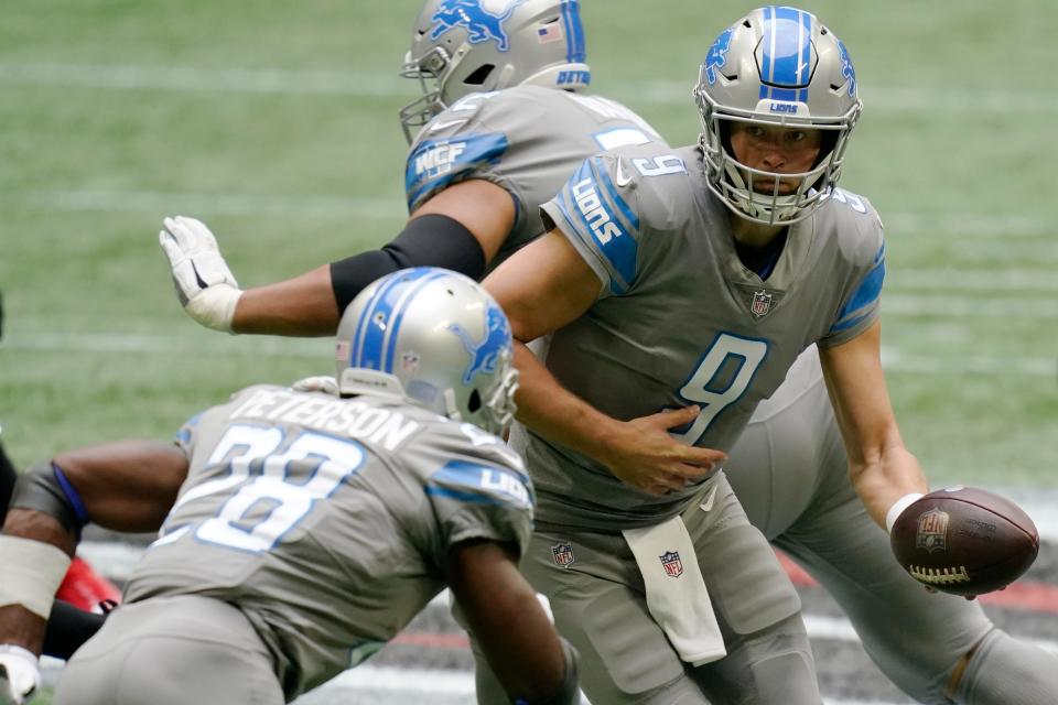 Lions quarterback Matthew Stafford hands the ball off to Lions running back Adrian Peterson against the Falcons during the first half on Sunday, Oct. 25, 2020, in Atlanta.