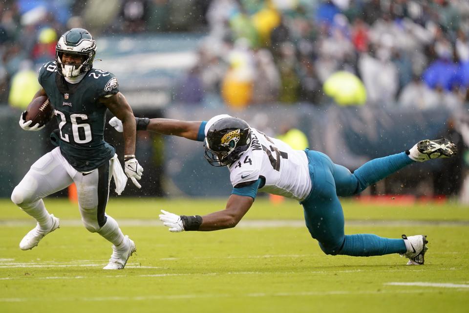 Philadelphia Eagles' Miles Sanders runs with the ball past Jacksonville Jaguars' Travon Walker during the first half of an NFL football game Sunday, Oct. 2, 2022, in Philadelphia. (AP Photo/Matt Rourke)