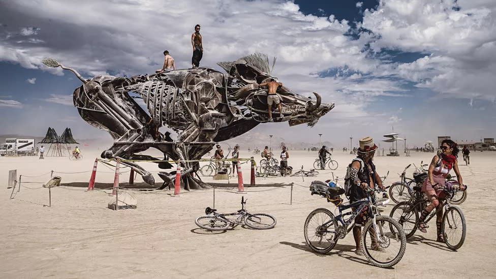 An awe-inspiring mechanical beast captivates Burners as they explore the desert on their bikes.