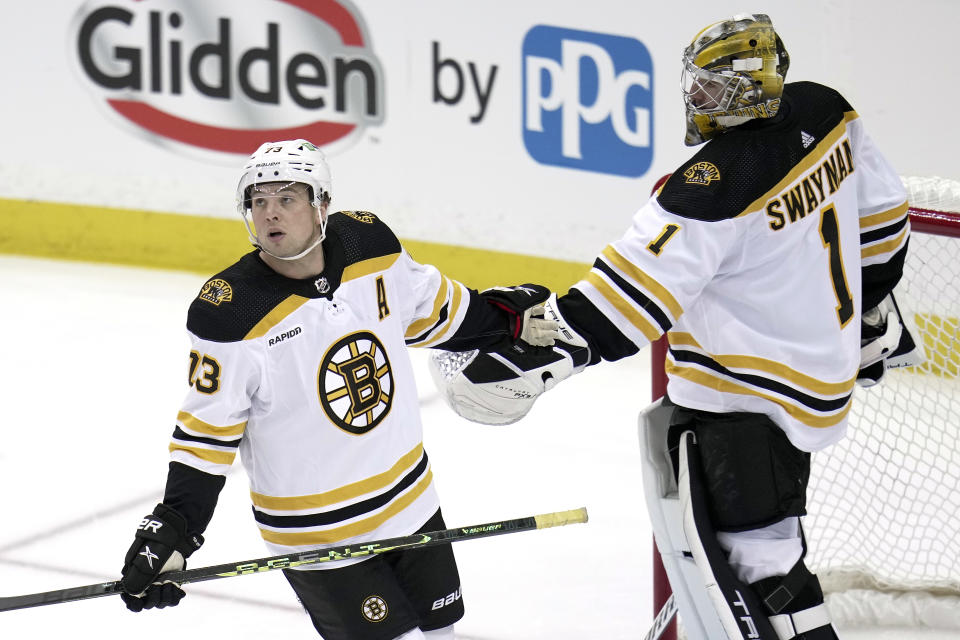 Boston Bruins' Charlie McAvoy celebrates his goal with goaltender Jeremy Swayman during the first period of an NHL hockey game against the Pittsburgh Penguins in Pittsburgh, Saturday, April 1, 2023. (AP Photo/Gene J. Puskar)