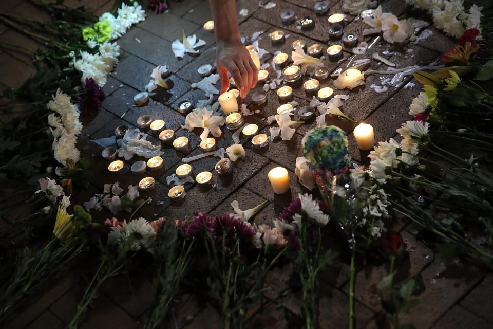 A man tends a makeshift candlelight vigil for those who died and were injured when a car plowed into a crowd of anti-fascist counter-demonstrators marching near a downtown shopping area. (Photo: Win McNamee via Getty Images)