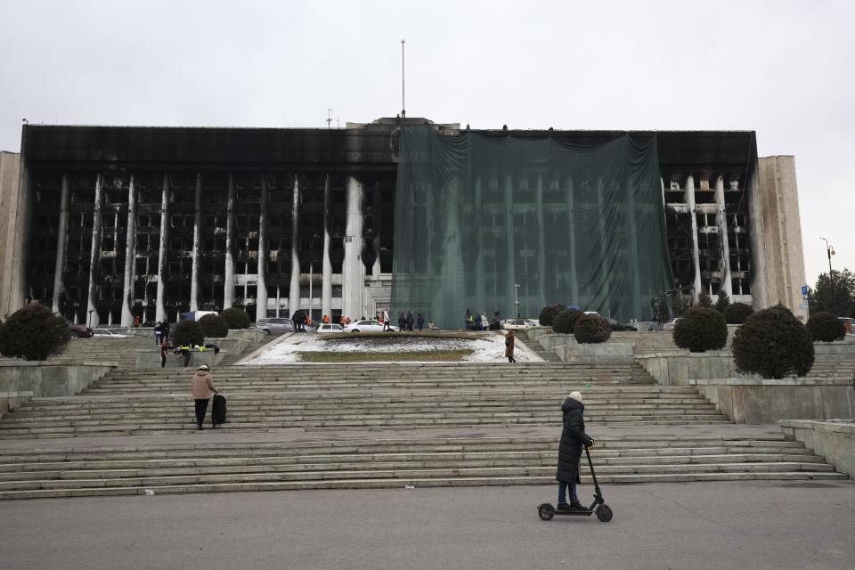 FILE - Municipal workers cover the burnt city hall building for repairing in Almaty, Kazakhstan, Thursday, Jan. 13, 2022. At Tokayev's request, 2,000 peacekeepers from the Moscow-led CSTO security alliance were deployed to Kazakhstan, leading to speculation about possible direct intervention by the Kremlin. These fears did not come to pass, with the CSTO announcing in late January that its troops had pulled out without firing a single shot. (AP Photo/Sergei Grits, File)