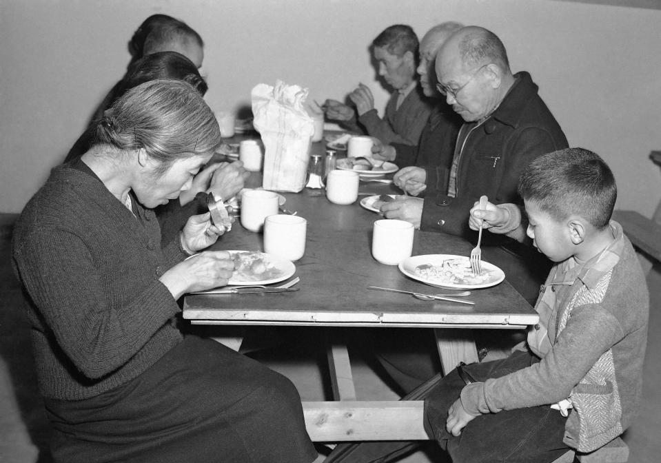 A group, old and young, eats heartily in the Granada Center Mess Hall in Granada, Colo., on Feb. 23, 1943.