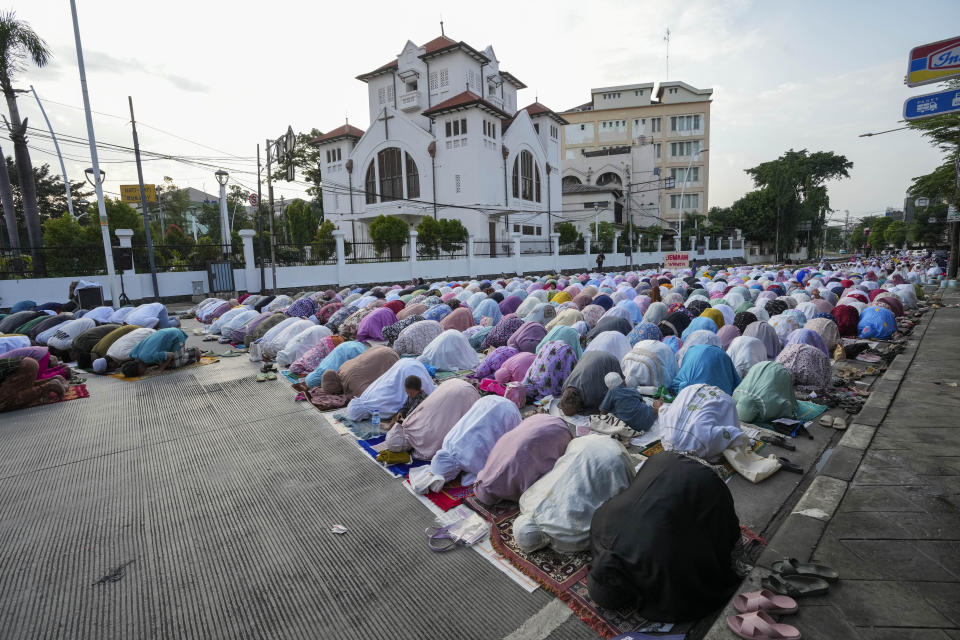 Muslims perform a morning prayer marking the Eid al-Adha holiday on a street in Jakarta, Indonesia, Thursday, June 29, 2023. Muslims around the world will celebrate Eid al-Adha, or the Feast of the Sacrifice, slaughtering sheep, goats, cows and camels to commemorate Prophet Abraham's readiness to sacrifice his son Ismail on God's command. (AP Photo/Tatan Syuflana)