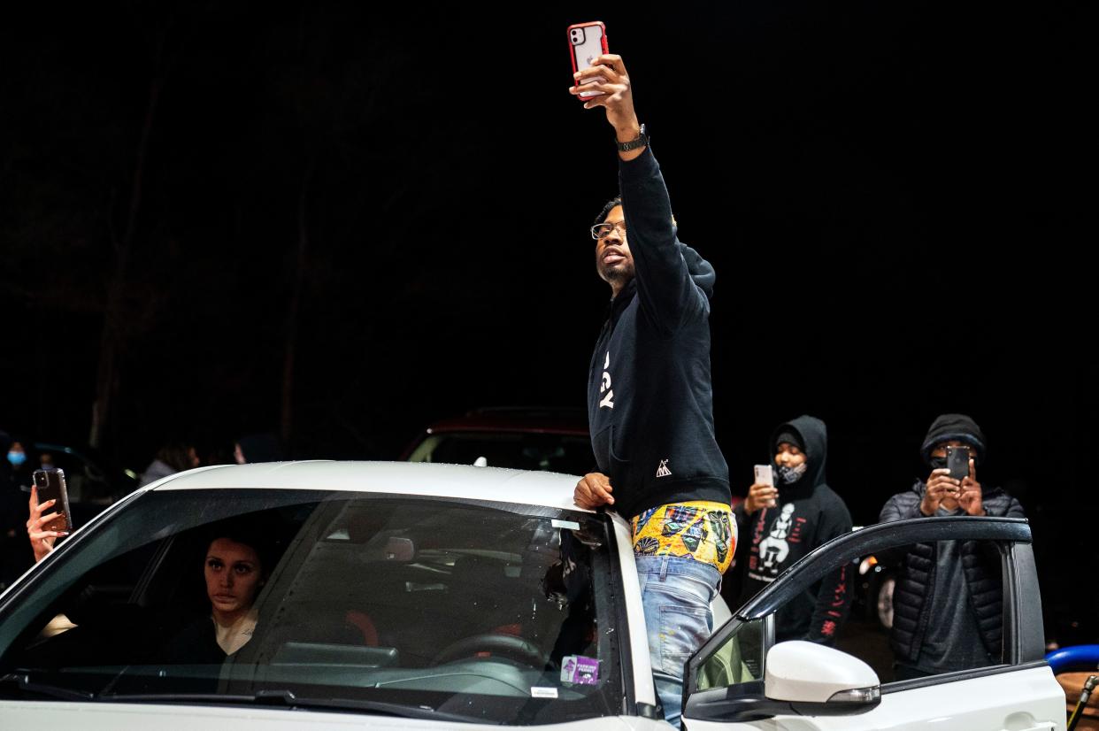 Motorists record video with their mobile phones as a line of police advances into a gas station in an effort to push back demonstrators gathered for a protest against the police shooting of Daunte Wright on Monday, April 12, 2021, in Brooklyn Center, Minn.