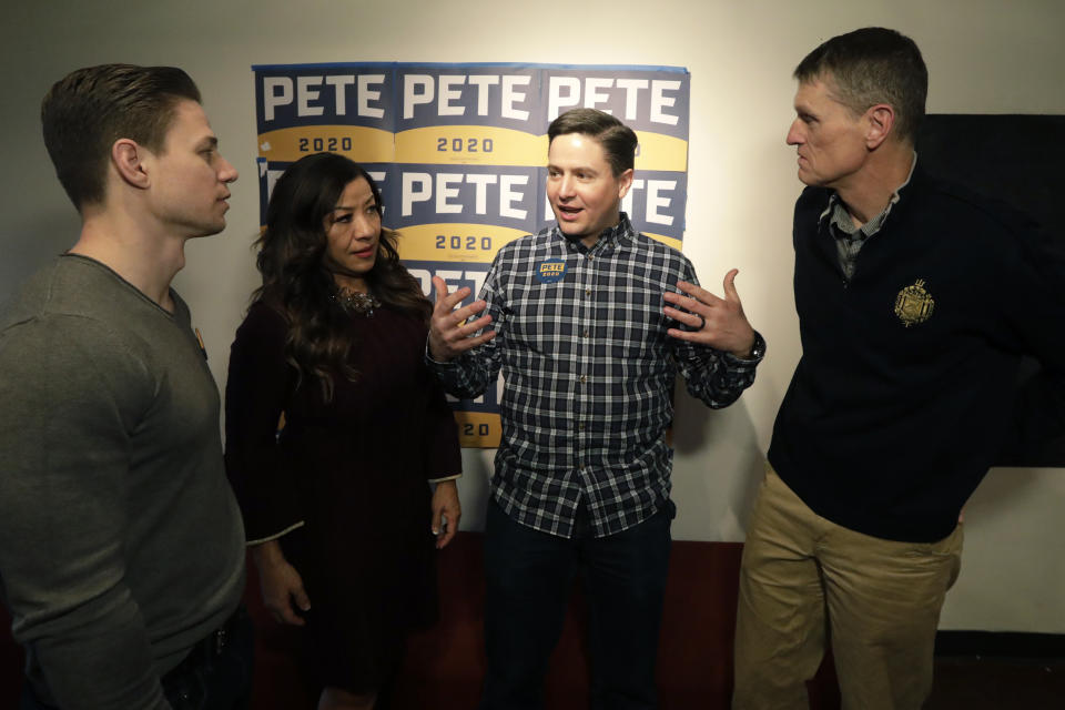 In this Tuesday, Feb. 25, 2020, photo, Taylor West, third from left, speaks with others during a "Republicans in Utah supporting Pete Buttigieg" debate watch party, in Salt Lake City. Democratic presidential candidates like to boast about their ability to lure away disaffected Republican voters. If there’s a place to test their skills, it’s Utah. (AP Photo/Rick Bowmer)