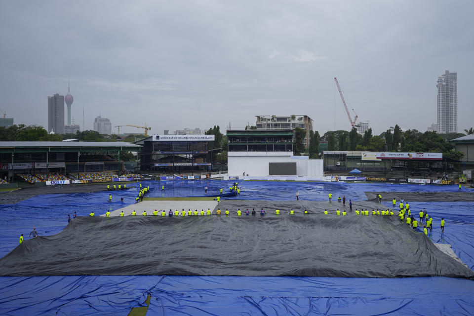 Ground staff cover the filed as it rains during the second day of the second cricket test match between Sri Lanka and Pakistan in Colombo, Sri Lanka on Tuesday, Jul. 25. (AP Photo/Eranga Jayawardena)