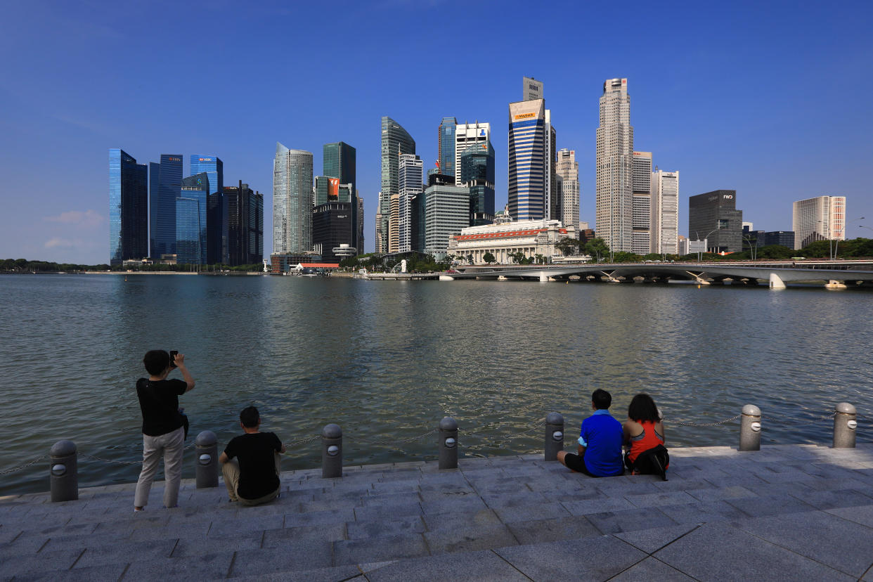 People look at the city skyline on June 7, 2021 in Singapore. Singapore enters a month long heightened alert from May 16 to June 13 to curb the spread of COVID-19 cases in the local community. New restrictions on movements and activities have been introduced such as limiting social interaction to two, prohibiting dining out and a reduced operating capacity at shopping malls, offices and attractions. (Photo by Suhaimi Abdullah/NurPhoto via Getty Images)