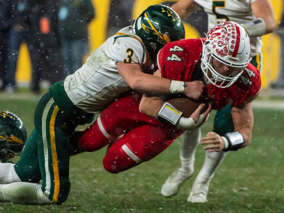 Moon's Dylan Sleva is brought down by Penn-Trafford's Seth Dunlap during their WPIAL 5A Championship Saturday at Heinz Field.[Lucy Schaly/For BCT]