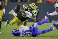 Green Bay Packers' AJ Dillon is stopped by Los Angeles Rams' Darious Williams during the second half of an NFL football game Sunday, Nov. 28, 2021, in Green Bay, Wis. (AP Photo/Aaron Gash)