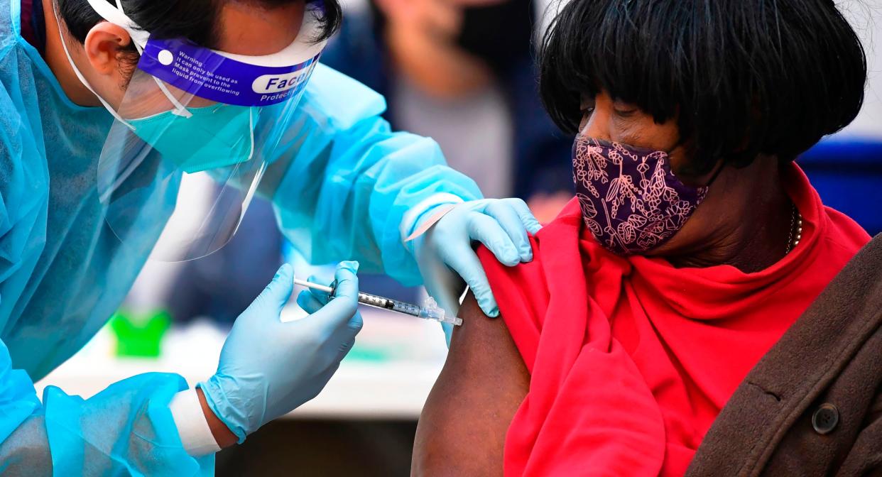 Registered Nurse Angelo Bautista administers the Moderna COVID-19 vaccine to eligible people identified by homeless service agencies from the parking lot of the LA Mission on Feb. 24 in Los Angeles. (Photo: FREDERIC J. BROWN/AFP via Getty Images)