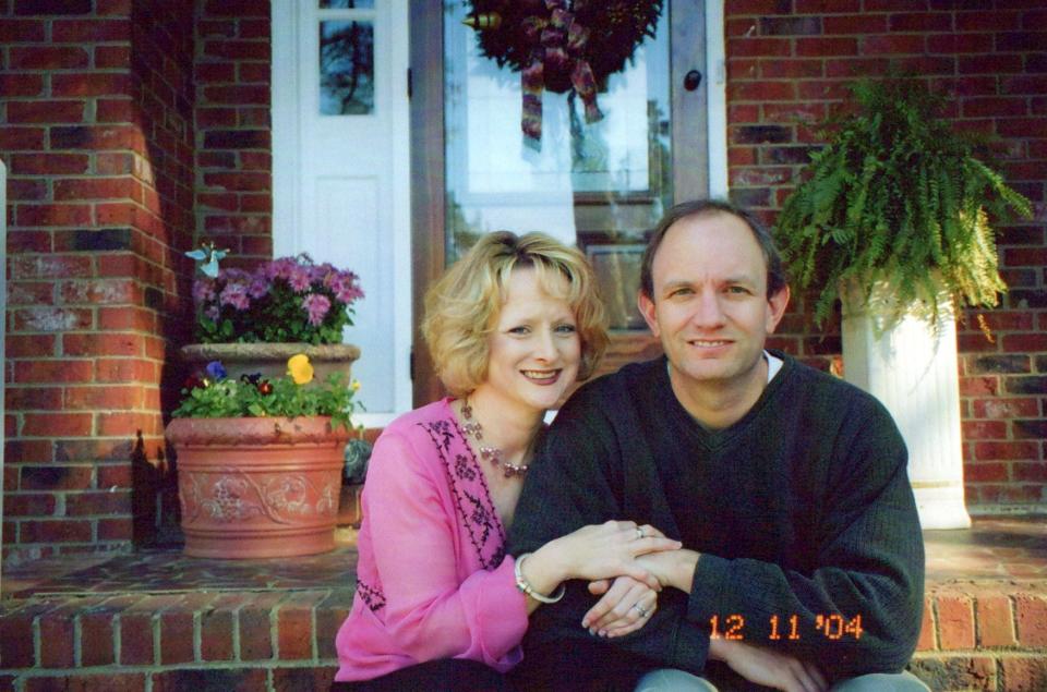 The author and her ex-husband, Ed, sitting on the steps of a brick home.