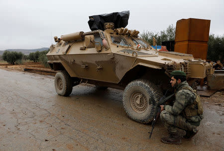 A member of Turkey-backed Free Syrian Army police forces secures the road as they escort a convoy near Azaz, Syria January 26, 2018. REUTERS/Umit Bektas