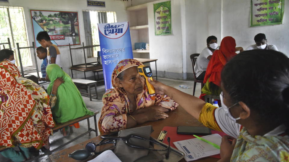 In this photo provided by Bidyanondo Foundation, doctors of boat hospital check patients, in Chandpur district in eastern Bangladesh, on Sept. 12, 2020. A Bangladeshi charity has set up a floating hospital turning a small tourist boat into a healthcare facility to provide services to thousands of people affected by this year's devastating floods that marooned millions. (Bidyanondo Foundation via AP)