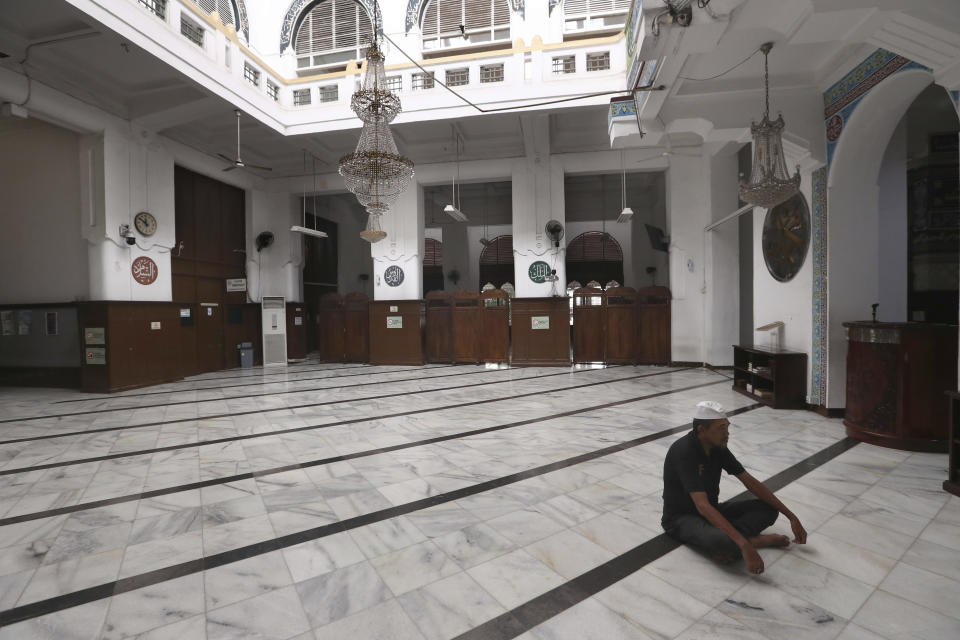 A man prays at an empty mosque in Jakarta, Indonesia, Friday, April 10, 2020. Mosques usually filled for Friday prayers and streets normally clogged with cars and motorcycles were empty as authorities in Indonesia's capital enforced stricter measures to halt the coronavirus' spread after deaths spiked in the past week. (AP Photo/Tatan Syuflana)