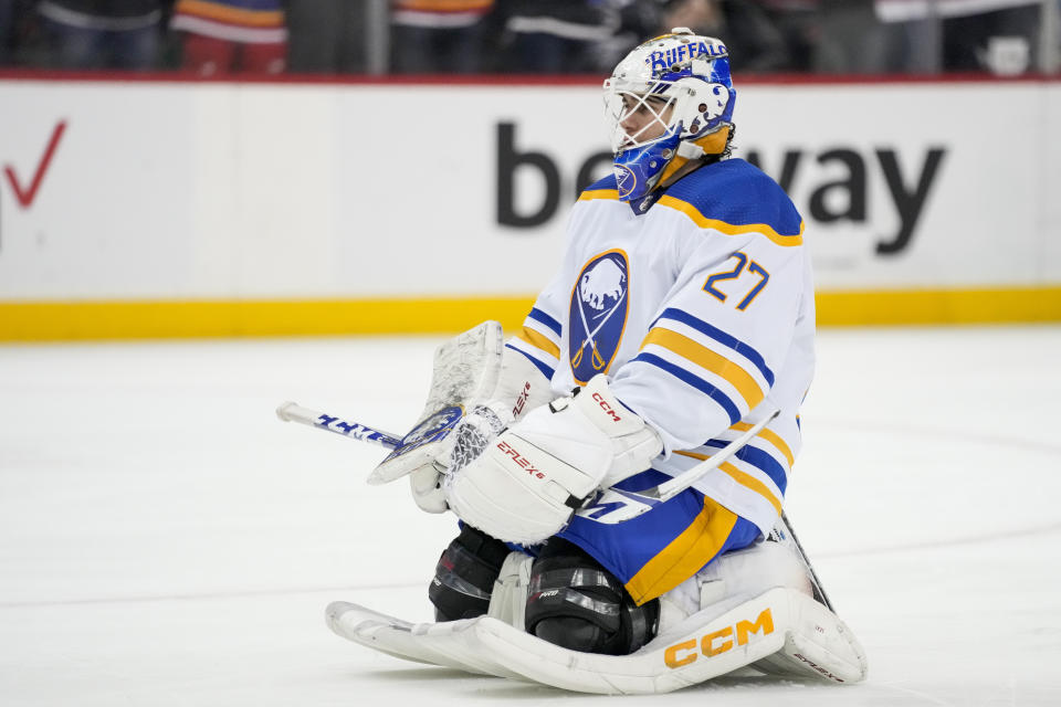 Buffalo Sabres goaltender Devon Levi (27) kneels before his goal during a pause in play in the second period of an NHL hockey game against the New Jersey Devils, Tuesday, April 11, 2023, in Newark, N.J. (AP Photo/John Minchillo)