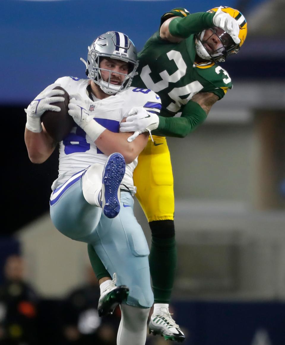 Dallas Cowboys tight end Jake Ferguson (87) catches a pass in front of Green Bay Packers safety Jonathan Owens (34) during the second quarter of their wild-card playoff game Jan. 14 at AT&T Stadium in Arlington, Texas.