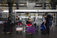 Passengers wearing face masks arrive at Adolfo Suarez-Barajas international airport, outskirts Madrid, Spain, Sunday, June 21, 2020. Spain opened its borders to European tourists on Sunday in a bid to kickstart its vital tourism economy, but Brazil and South Africa reported record new levels of coronavirus infections. (AP Photo/Bernat Armangue)