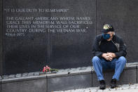 Vietnam Veteran Kitch Kichula, wearing a protective face mask as a precaution against the coronavirus, pays his respects at the at the Vietnam War Memorial, in Philadelphia, on Memorial Day, Monday, May 25, 2020. (AP Photo/Matt Rourke)