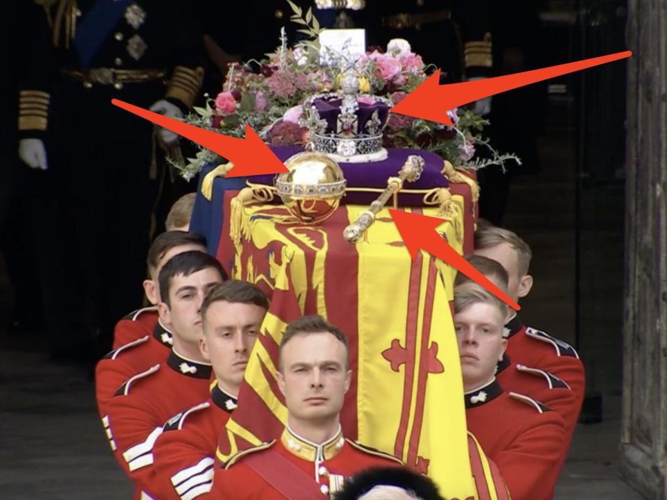 arrows pointing to the crown scepter and orb on the queen's coffin being carried by guards