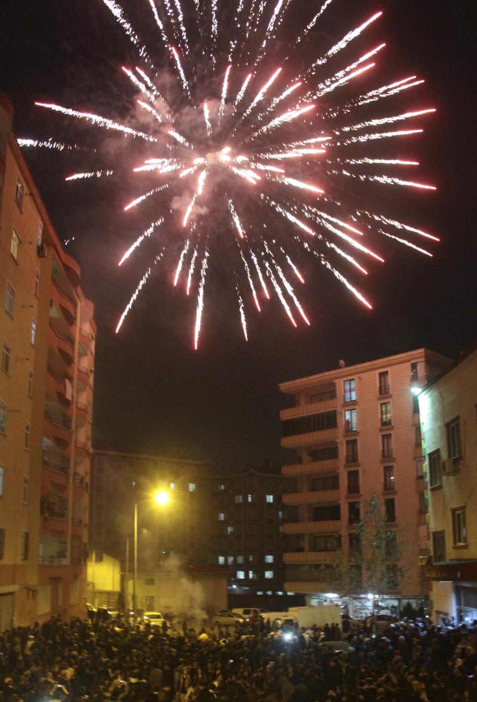 Fireworks explode overhead as people celebrate in Diyarbakir, after Kurdish forces took full control of Kobani