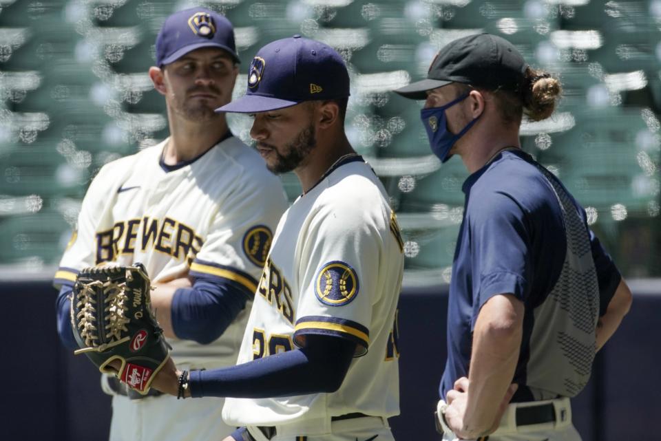 Milwaukee Brewers' Justin Grimm, Devin Williams and Josh Hader watch during a practice session Monday, July 13, 2020, at Miller Park in Milwaukee. (AP Photo/Morry Gash)