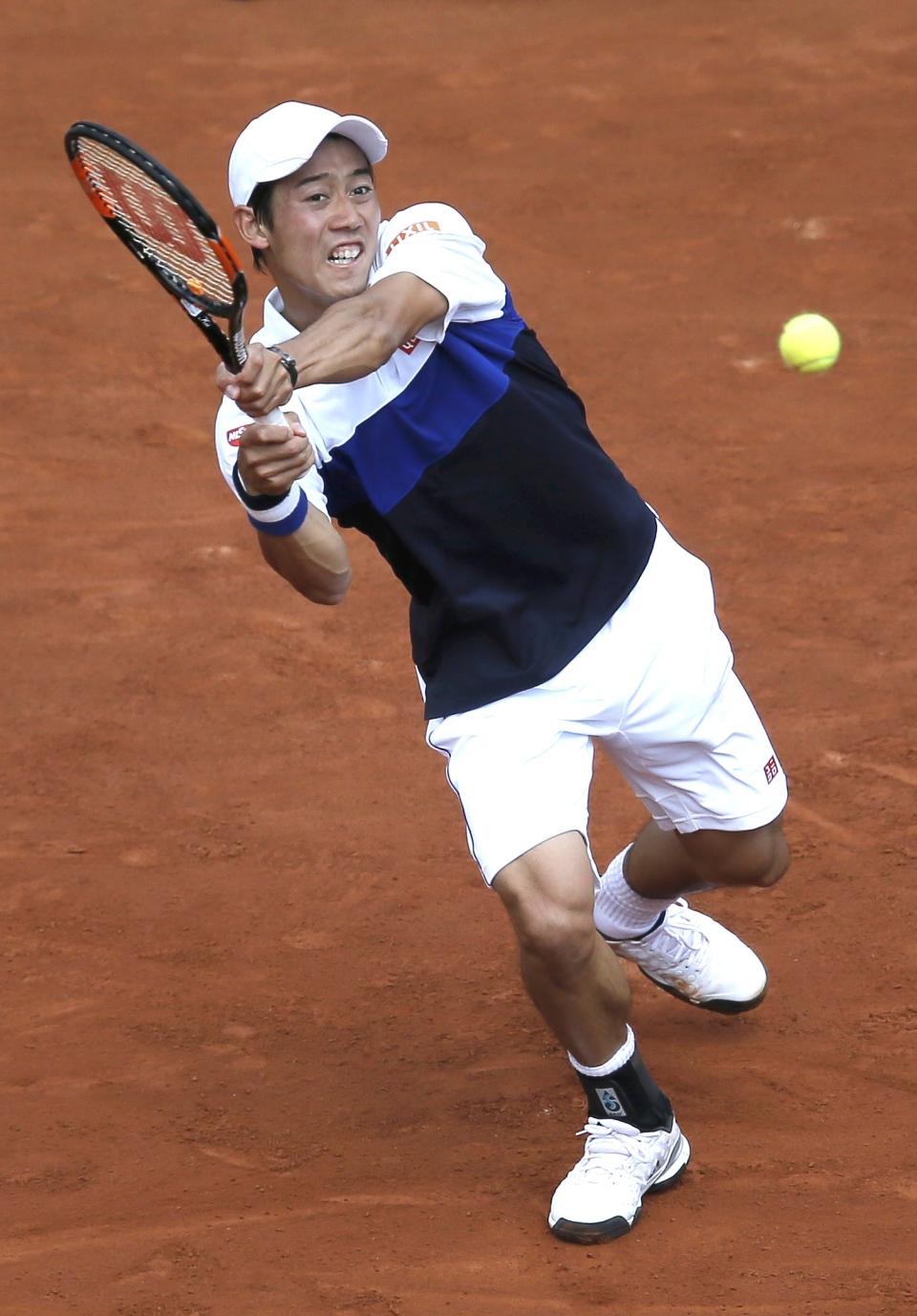 Kei Nishikori of Japan plays a shot to Thomaz Bellucci of Brazil during their men's singles match at the French Open tennis tournament at the Roland Garros stadium in Paris