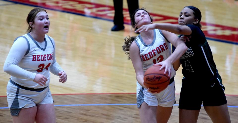 Bedford's Anna Gray of Bedford is fouled by Ava Lord of West Bloomfield during a 54-32 Bedford loss in the Division 1 state quarterfinals at the University of Detroit's Mercy Calihan Hall on Tuesday, March 19, 2024. Looking on left Nyah Mullins.