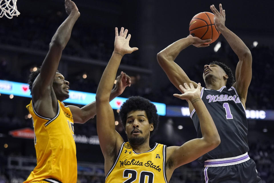 Kansas State forward David N'Guessan (1) shoots over Wichita State guard Harlond Beverly, center, and center Quincy Ballard, left, during the first half of an NCAA college basketball game Thursday, Dec. 21, 2023, in Kansas City, Mo. (AP Photo/Charlie Riedel)